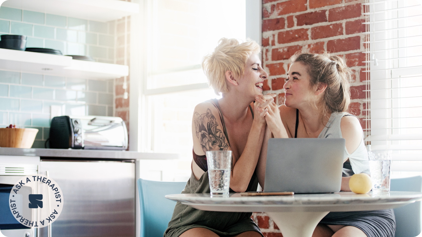 women couple sitting at table holding hands